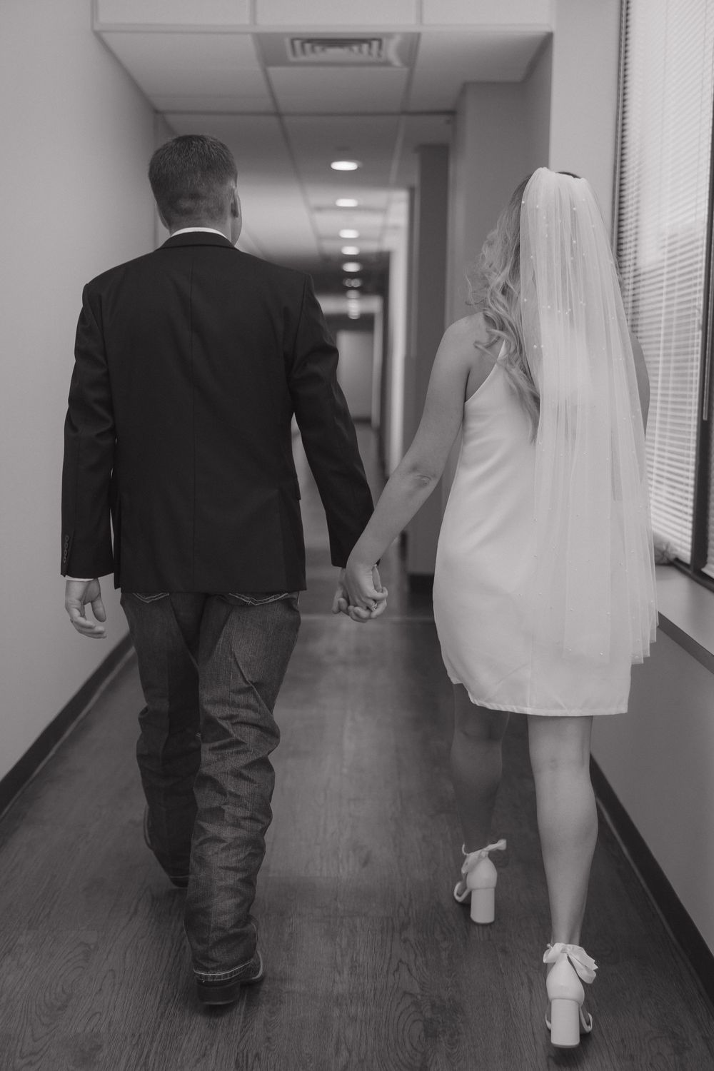 Black and white photos of a couple walking down a hallway after their courthouse wedding ceremony.