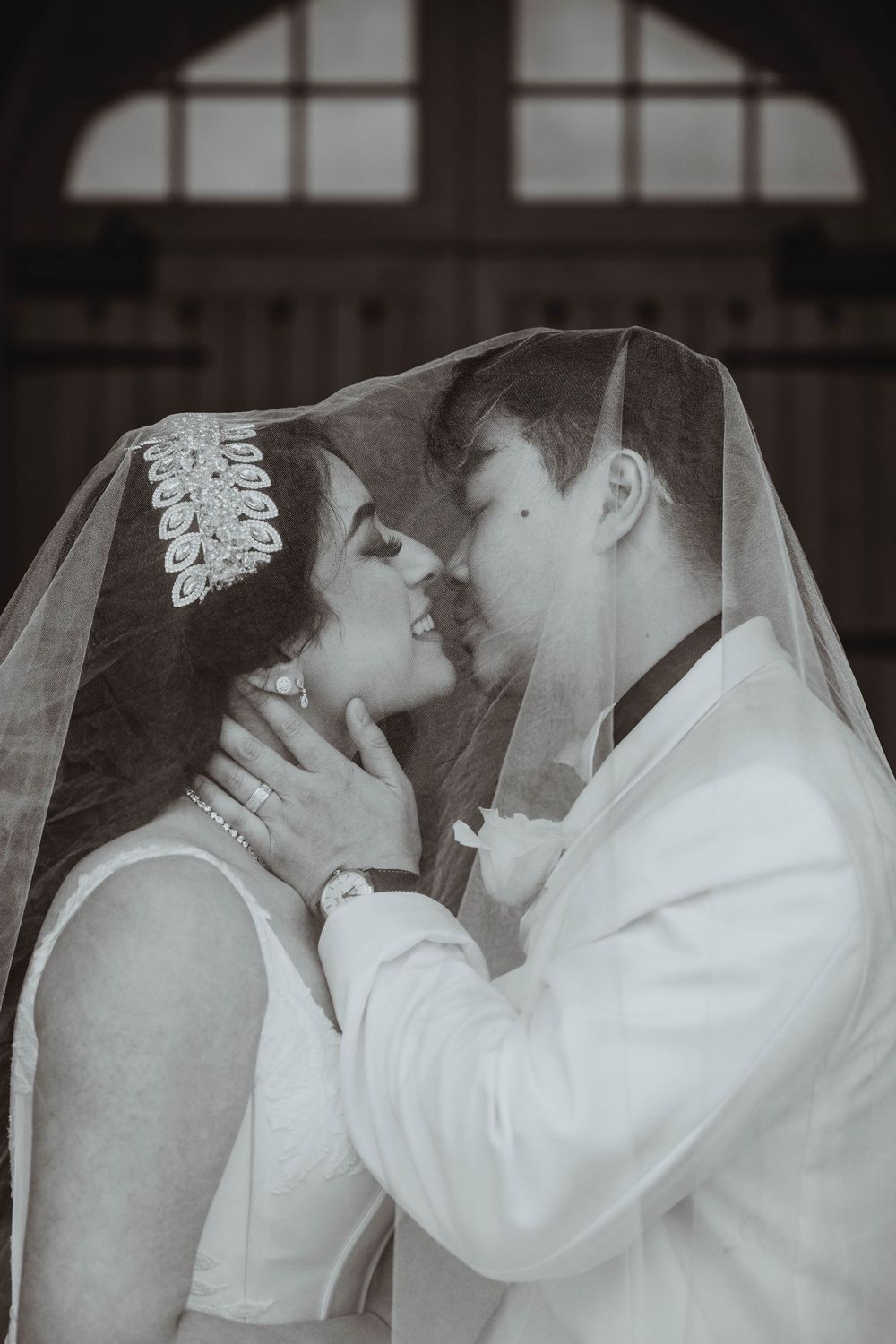 Elegant wedding portrait with couple posing dramatically in dark venue.