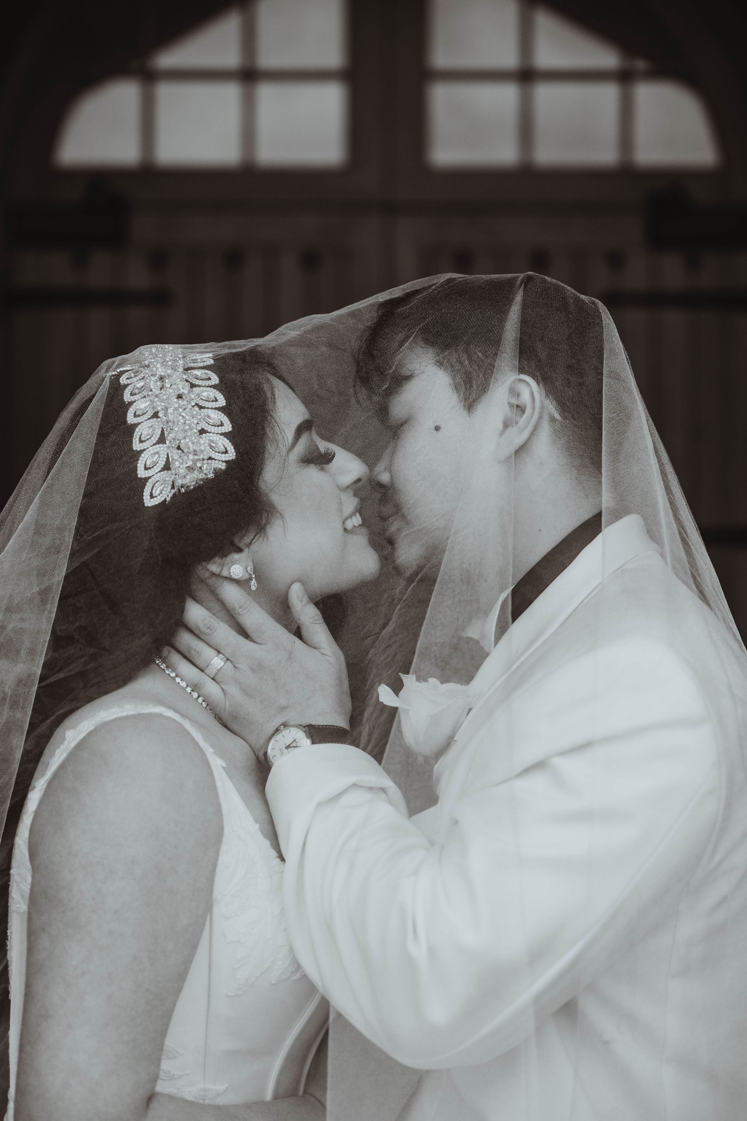 Elegant wedding portrait with couple posing dramatically in dark venue.