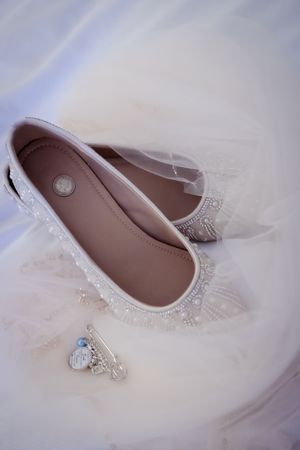 a brides shoes, earrings and necklace are photographed