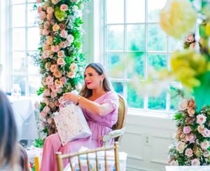 candid moment of woman opening gifts at babyshower