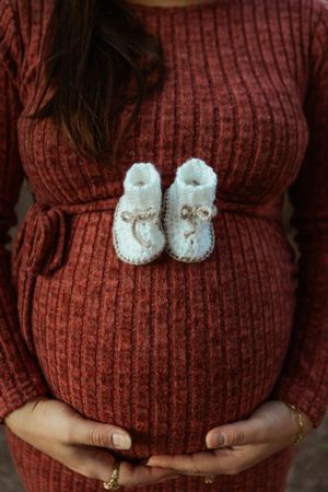 maternity picture features little booties balanced on pregnant belly