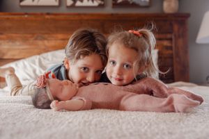 siblings snuggle their new baby sister
