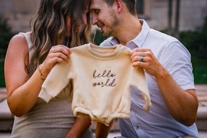 Pregnant woman posing with partner during a maternity session with warm, picture-perfect tones