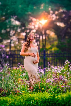 Outdoor maternity session with rich colors and a peaceful, glowing sunset behind the expecting mother.