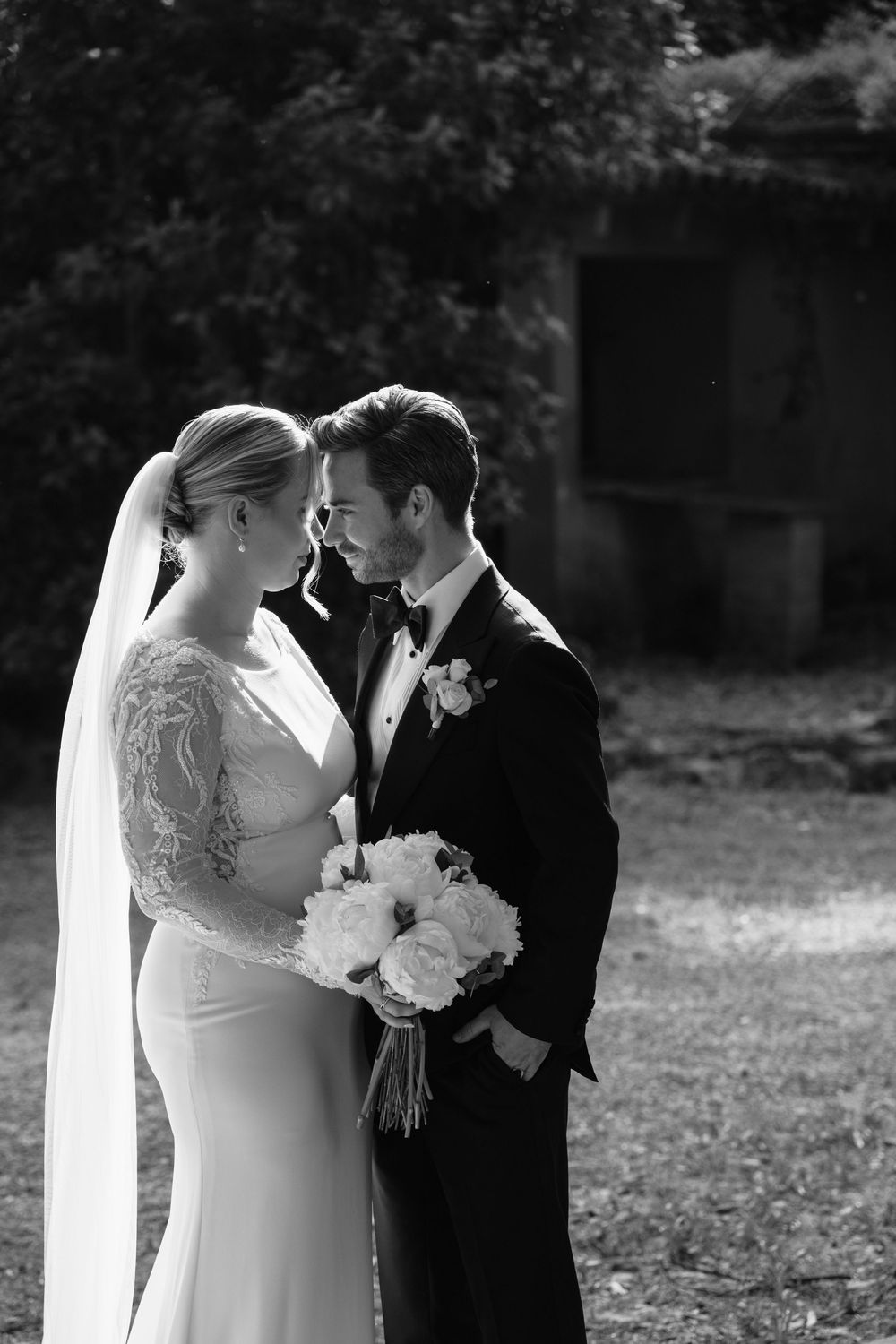 Black and white wedding photos show romantic moments between newlyweds in an outdoor garden setting.