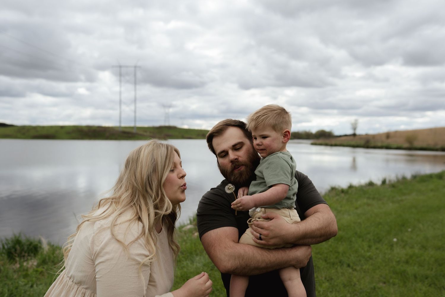 A romantic outdoor photo series showing a couple embracing by a lake.