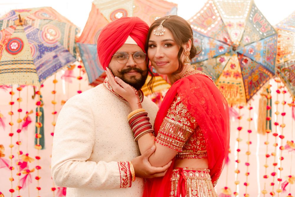 Mixed race couple on their wedding day posing in front of a colorful backdrop. Photographed by Shumesa Mohsin
