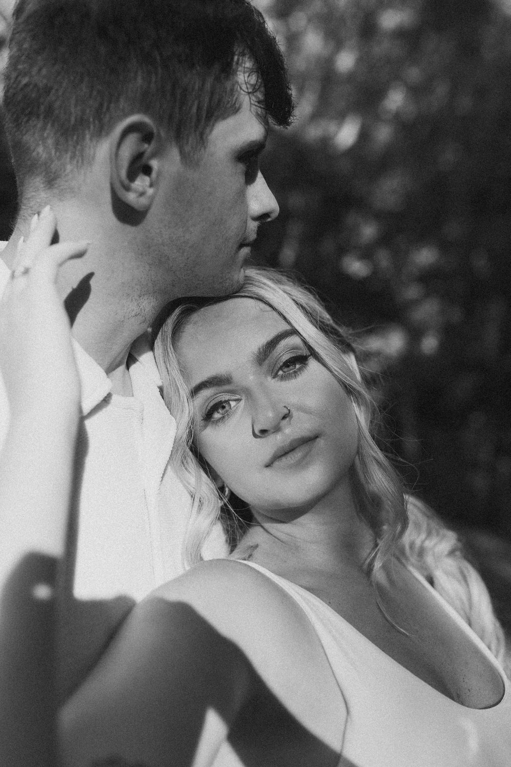 A black and white romantic photo series showing an intimate couple in close embrace and tender moments.