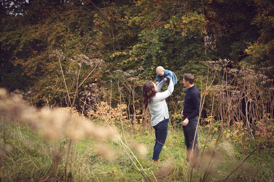 A joyful family enjoying a moment together in the tranquil surroundings of Dunnottar Woods, capturing the beauty of nature and connection