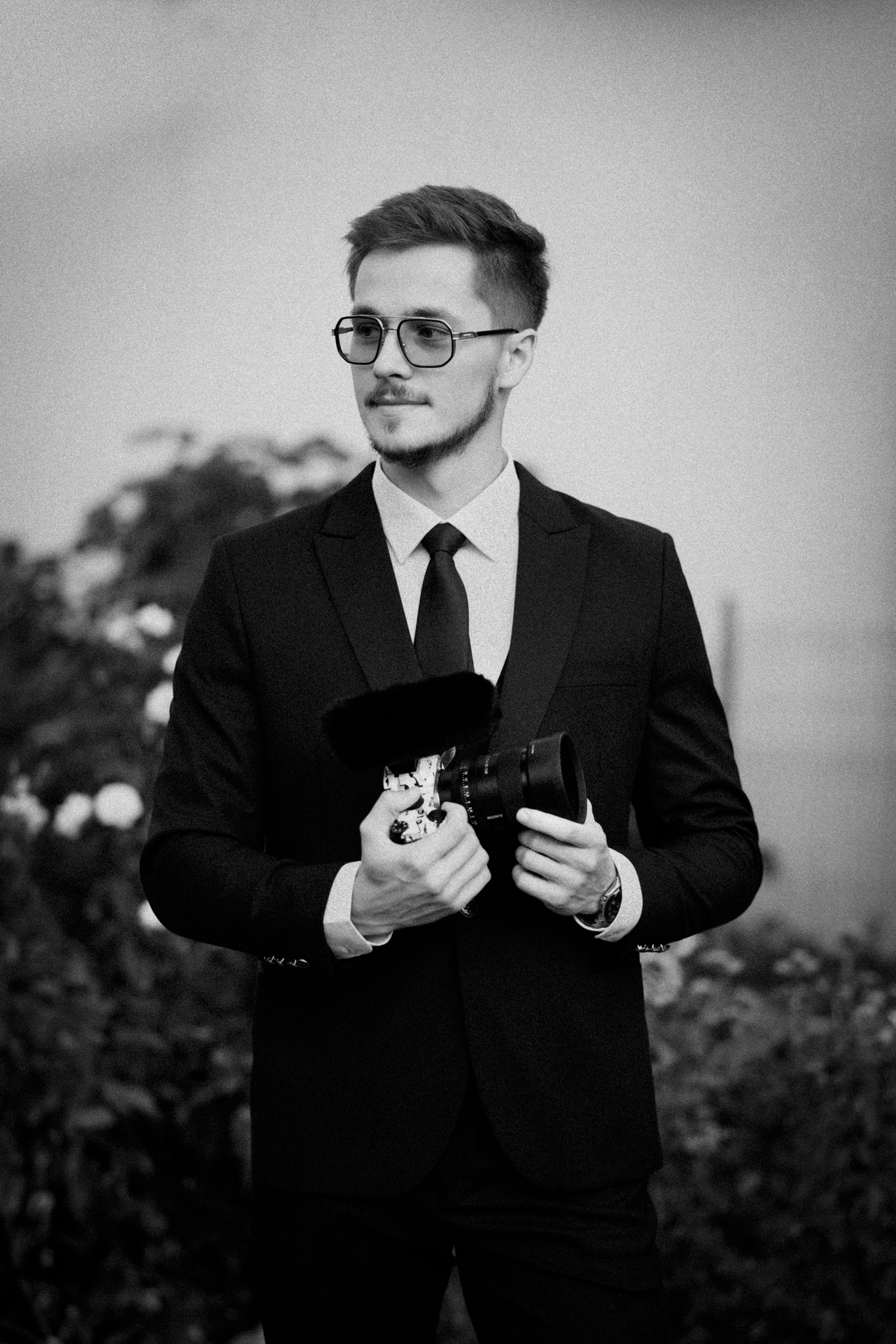 Black and white portraits of groom getting ready before ceremony.
