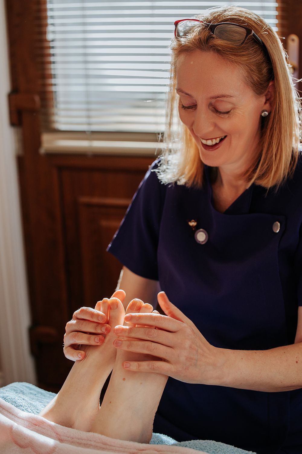 woman is massaging another persons feet during reflexology session for her holistic branding photo session