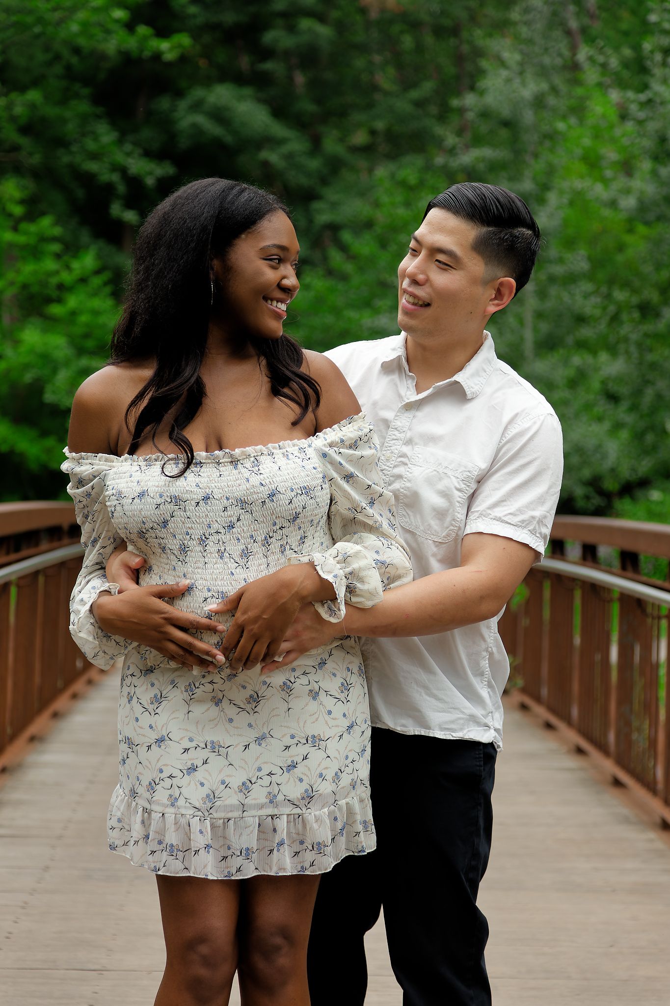 expecting couple embracing romantically surrounded by falling red rose petals on white background. Taken by BEXPRO at Edwards Gardens.