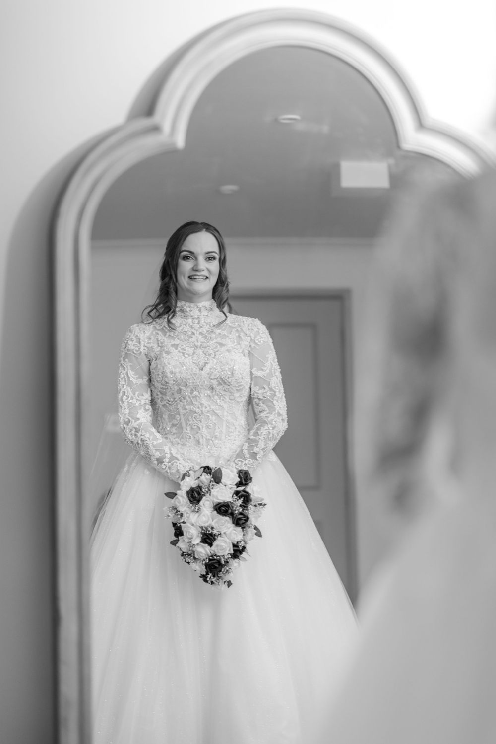 Black and white bridal portrait reflected in an ornate mirror.