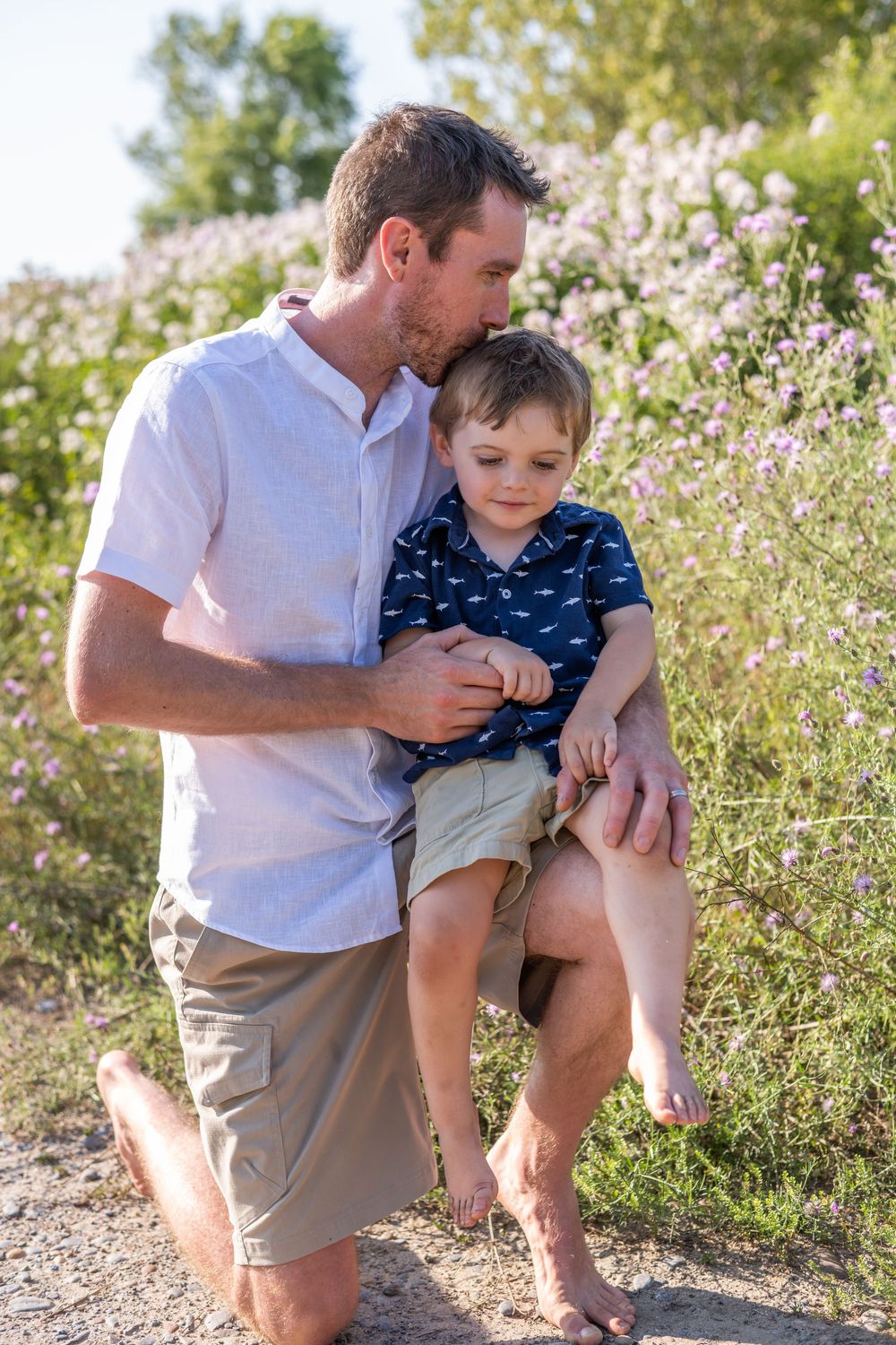 A parent and child share playful moments together among blooming wildflowers on a sunny day.Quinte West