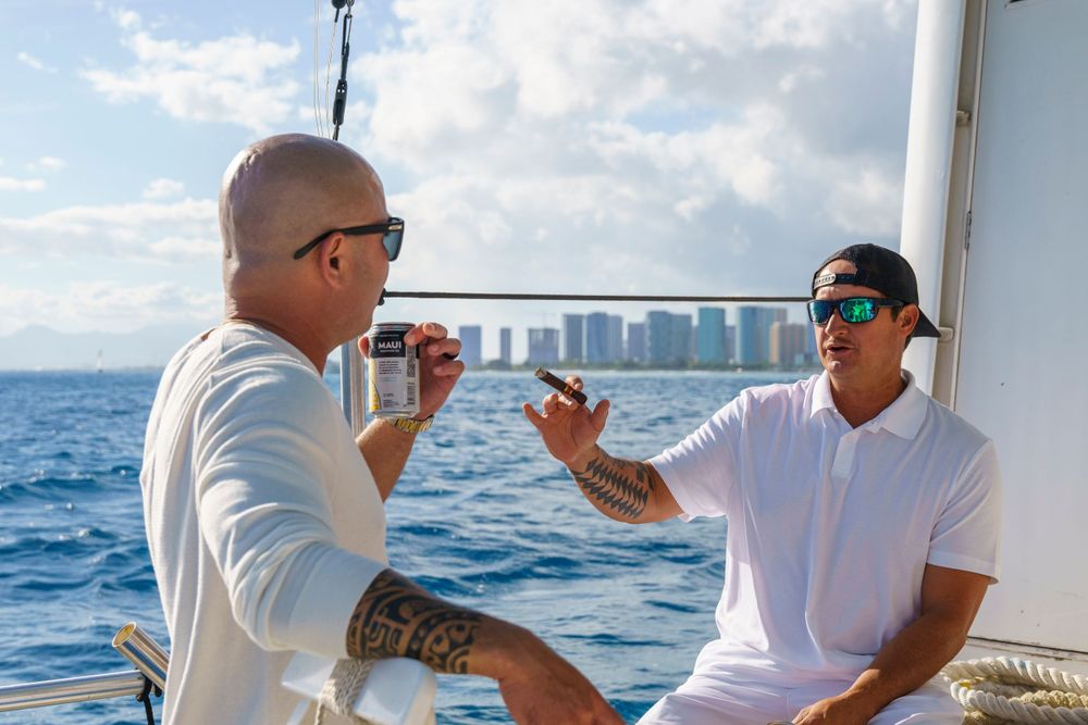 Friends socializing on a chartered boat deck against blue ocean waters.