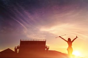 Silhouette of twirler in front of high school stadium with beautiful sunset
