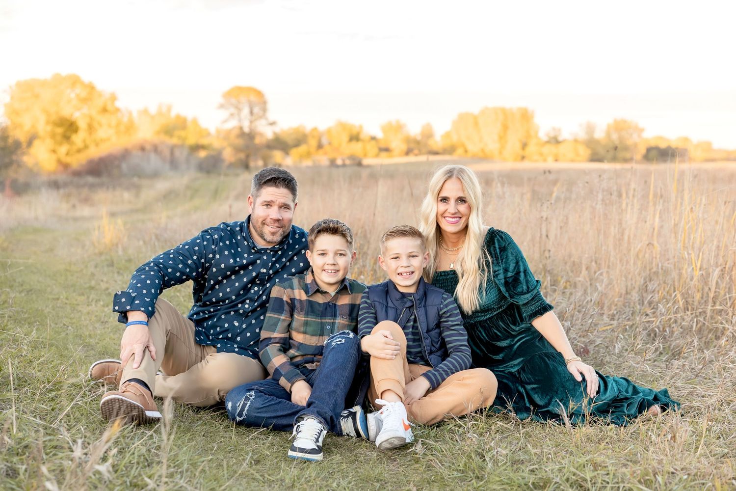 Family portrait session in a field during golden hour sunset. Clear Lake Photographer. Mason City Photographer.