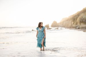 Serene beach scene with dramatic rock formations and gentle waves at golden hour.