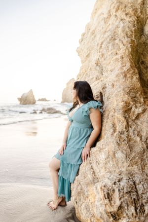 Tranquil beach setting with large limestone formations and soft sand at sunset.