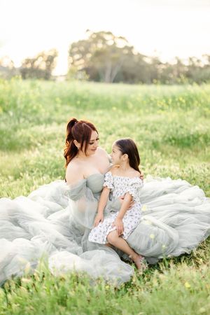 Intimate portrait on a blanket in a meadow with soft afternoon light.