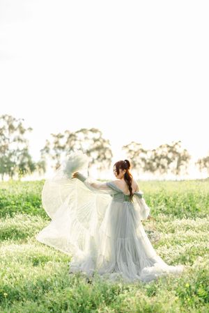 Ethereal shot of flowing white dress twirling in a spring meadow.