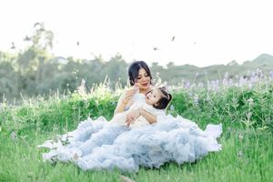 A romantic scene in a wildflower meadow with flowing blue tulle dress.