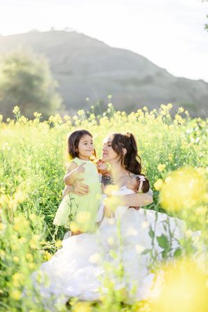 Joyful moment captured in a sun-drenched field of yellow wildflowers.