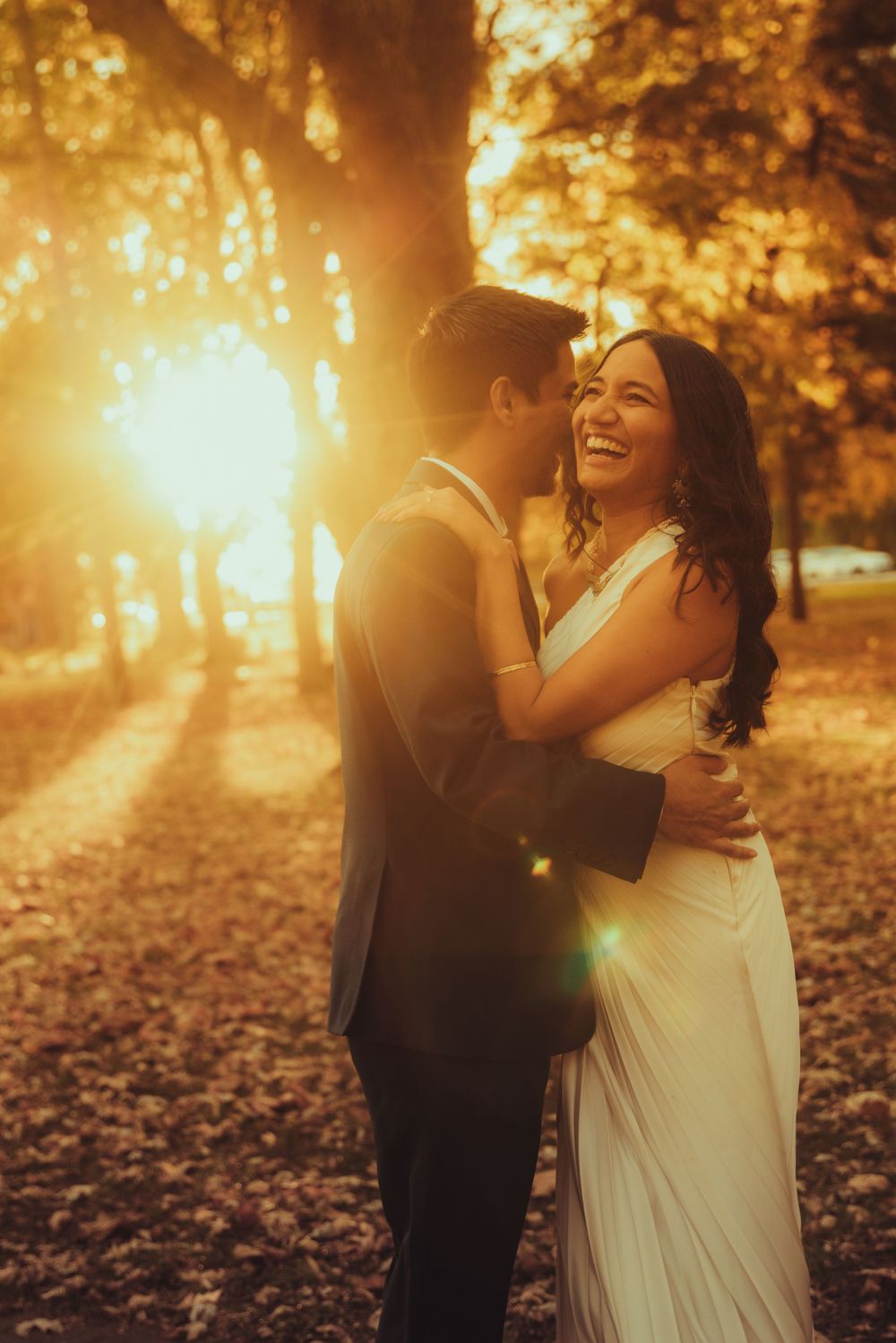 golden hour photo of bride and groom hugging  as the sun is behind them