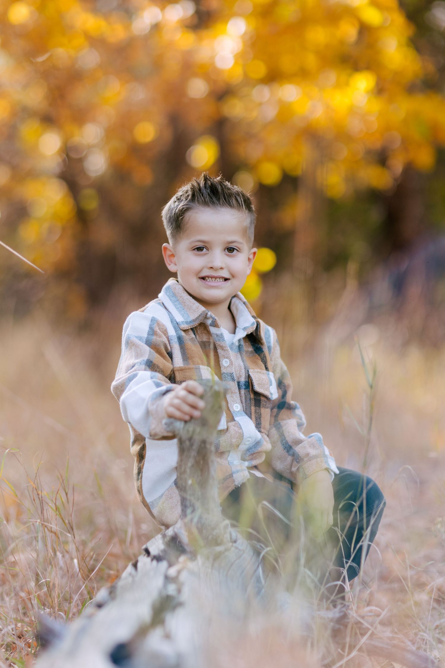 A candid outdoor portrait in tall grass with autumn colors and bokeh lighting effects.