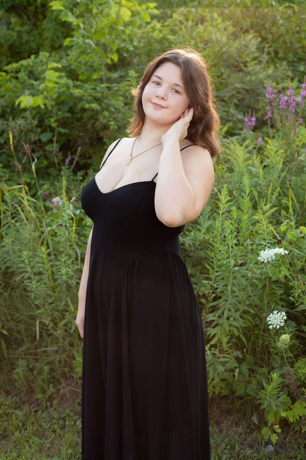A series of outdoor portraits featuring someone in a flowing black dress posing against lush greenery and flowers.