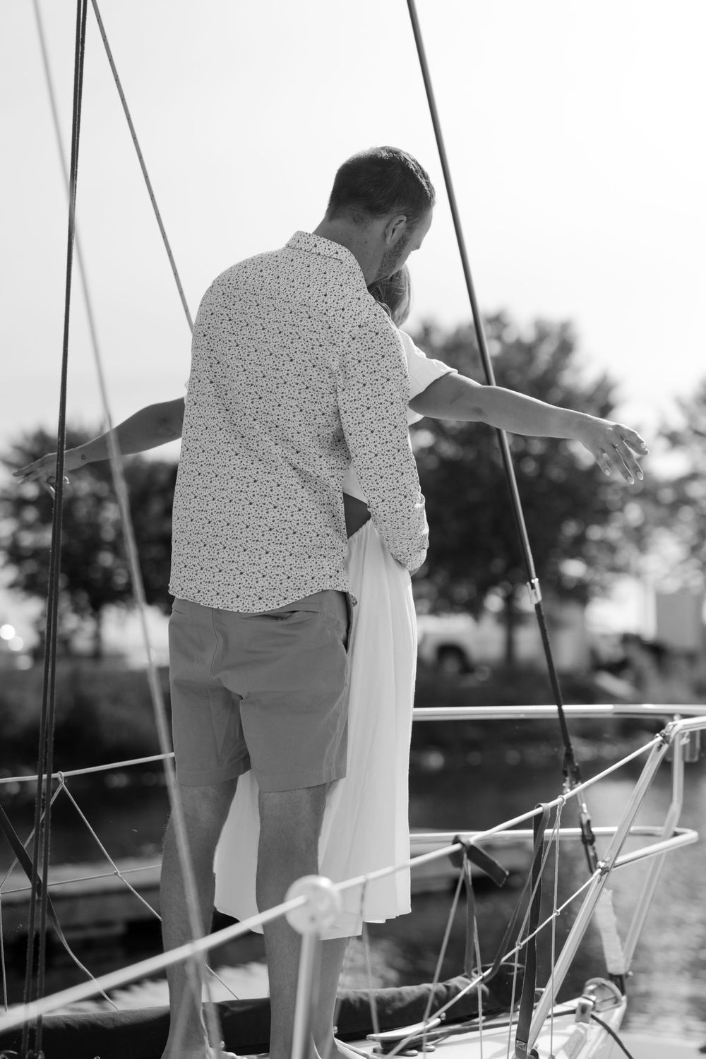 Series of black and white photos showing a couple's intimate moments on a sailboat.