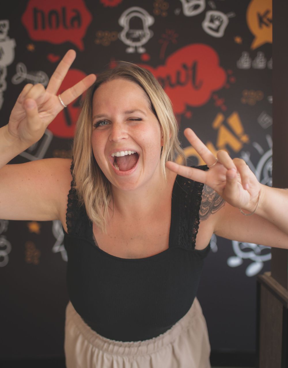 Energetic pose against wall with social media icons and graffiti background.