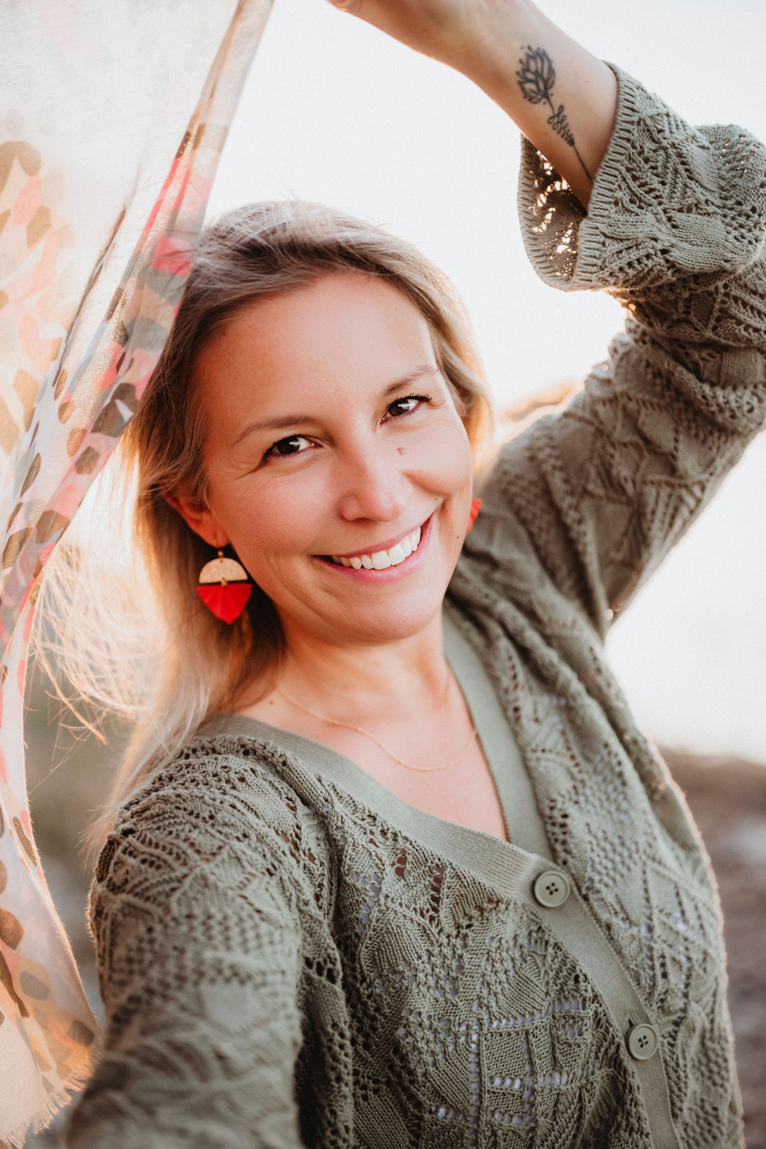 A collage of four photos showing someone wearing a cozy green knit sweater in different poses against a bright window.