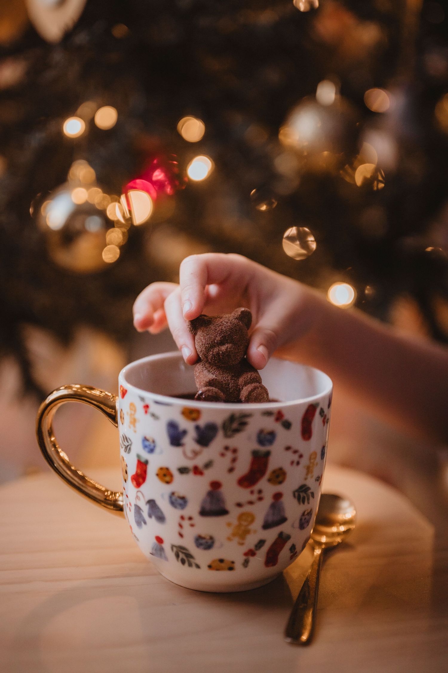A series of decorative teacups with whimsical patterns filled with chocolate mousse dessert against a bokeh light background.