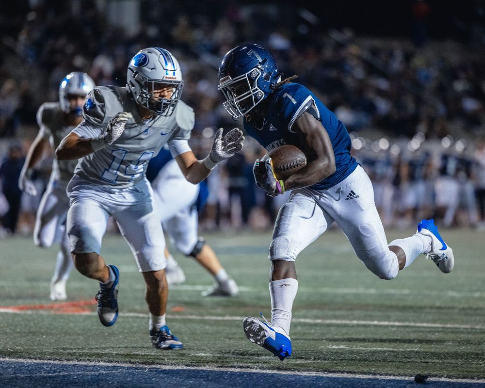 High School running back carries ball into the end-zone scoring a touchdown. Sports photography. Football.