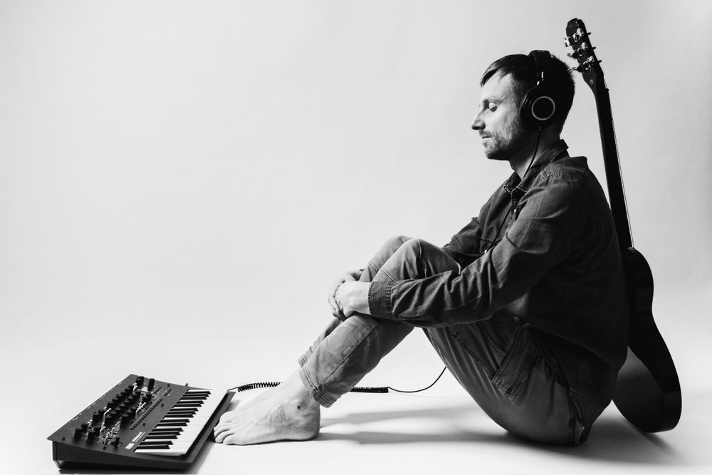 Musician posing with instruments in black and white photo series.