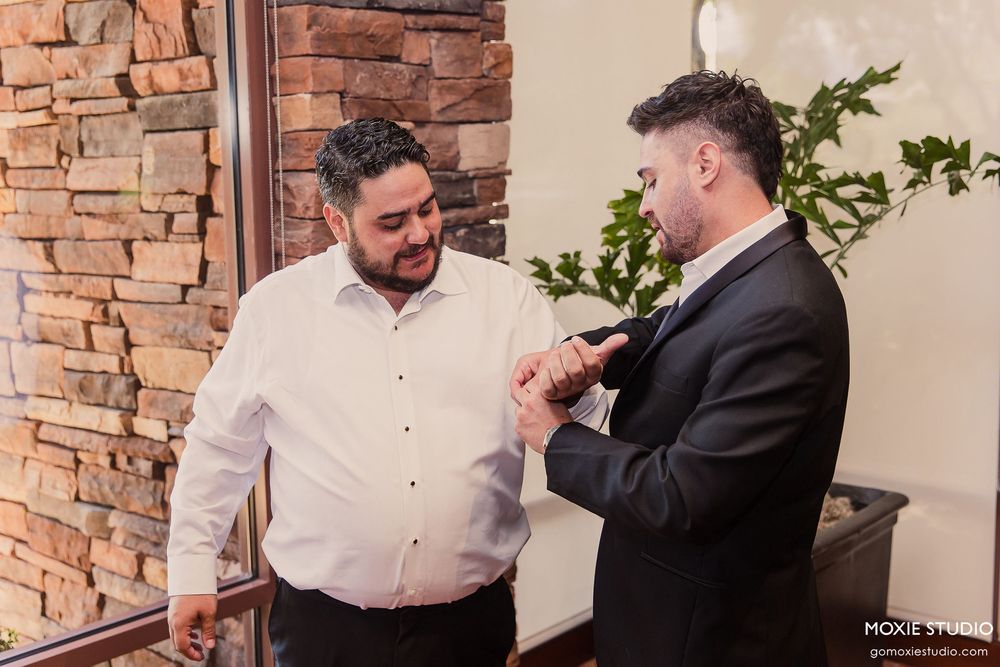 Two people in formal attire share an emotional embrace during what appears to be a wedding ceremony.