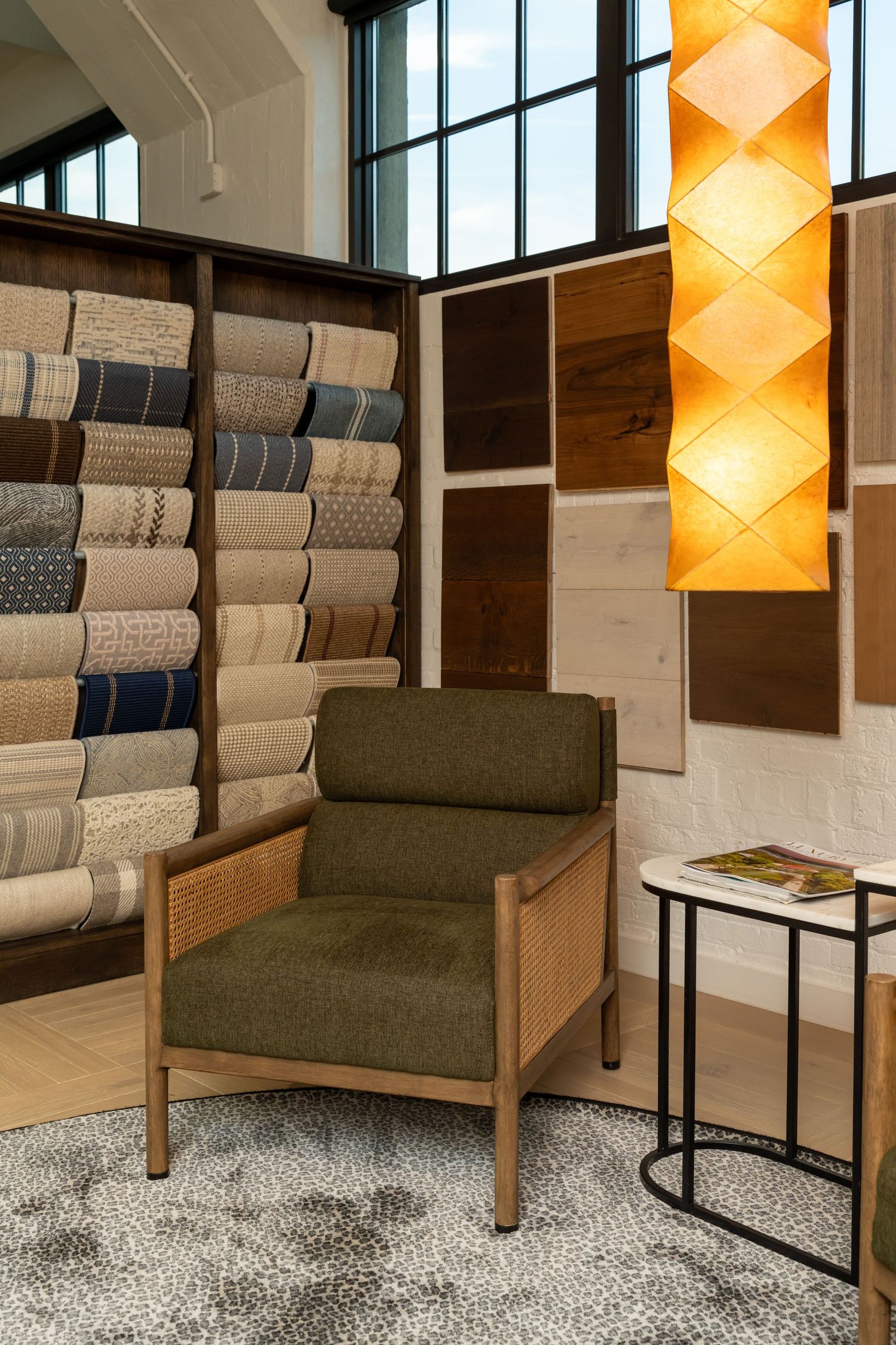 Mid-century modern armchair with fabric samples displayed on wall in showroom.