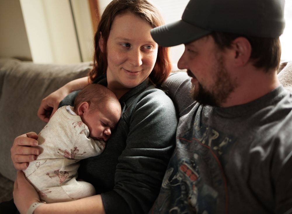 A tender family moment with a newborn baby in a cozy home setting.