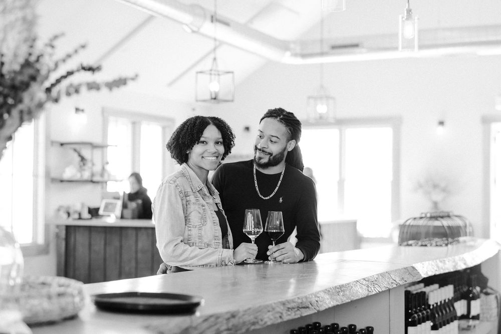 Two people enjoying wine and conversation at a bright, modern restaurant counter.