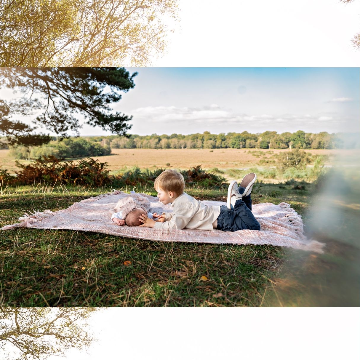 Little brother having a sweet moment with his baby sister during an outdoor family photo session in Hampshire, New Forest.