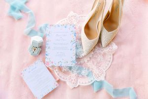 Pastel pink and blue wedding decor elements including ballet flats, lace trim, and delicate paper details.