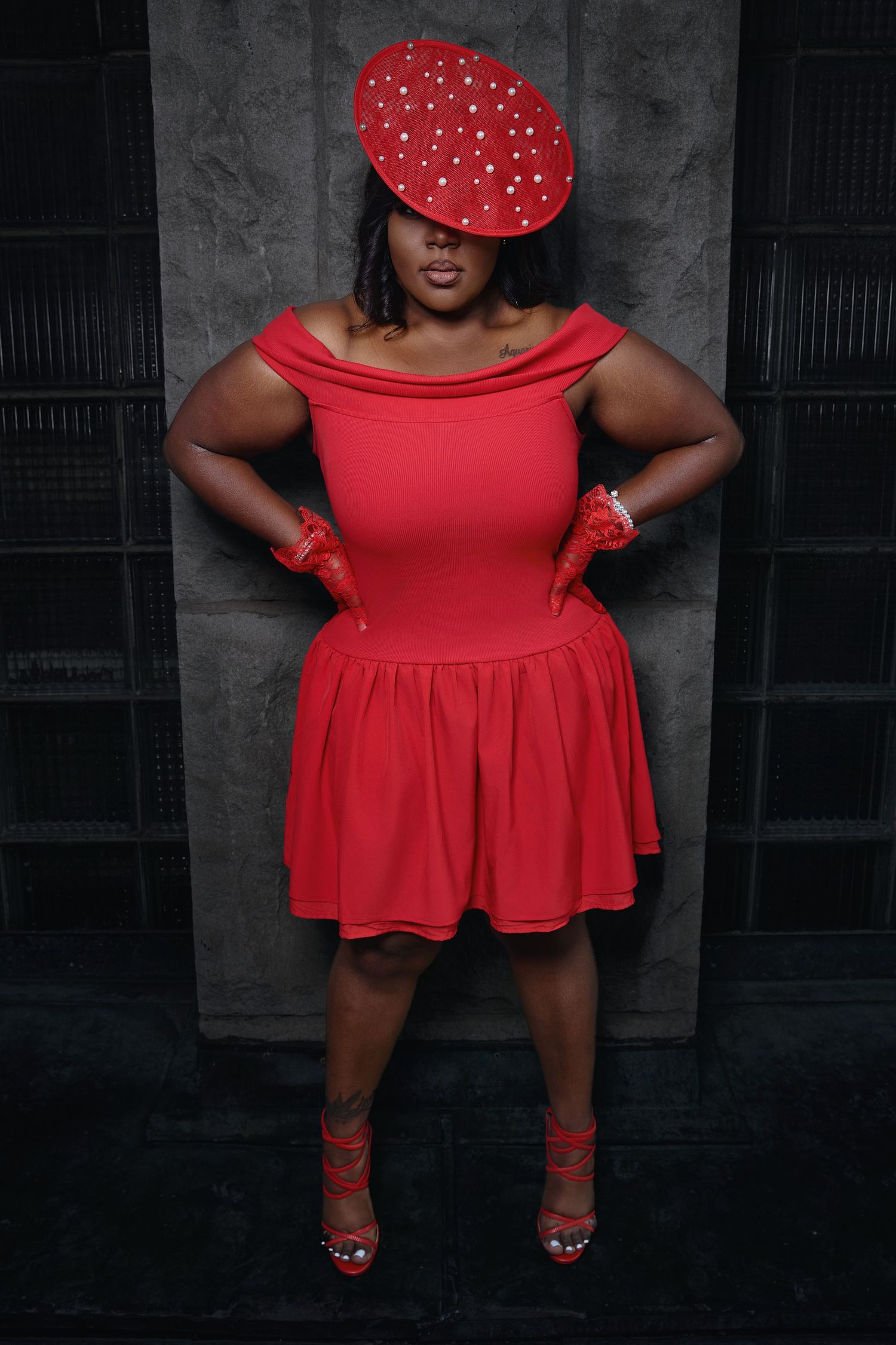 Fashion portrait featuring red polka dot dress and matching shoes against dark background.