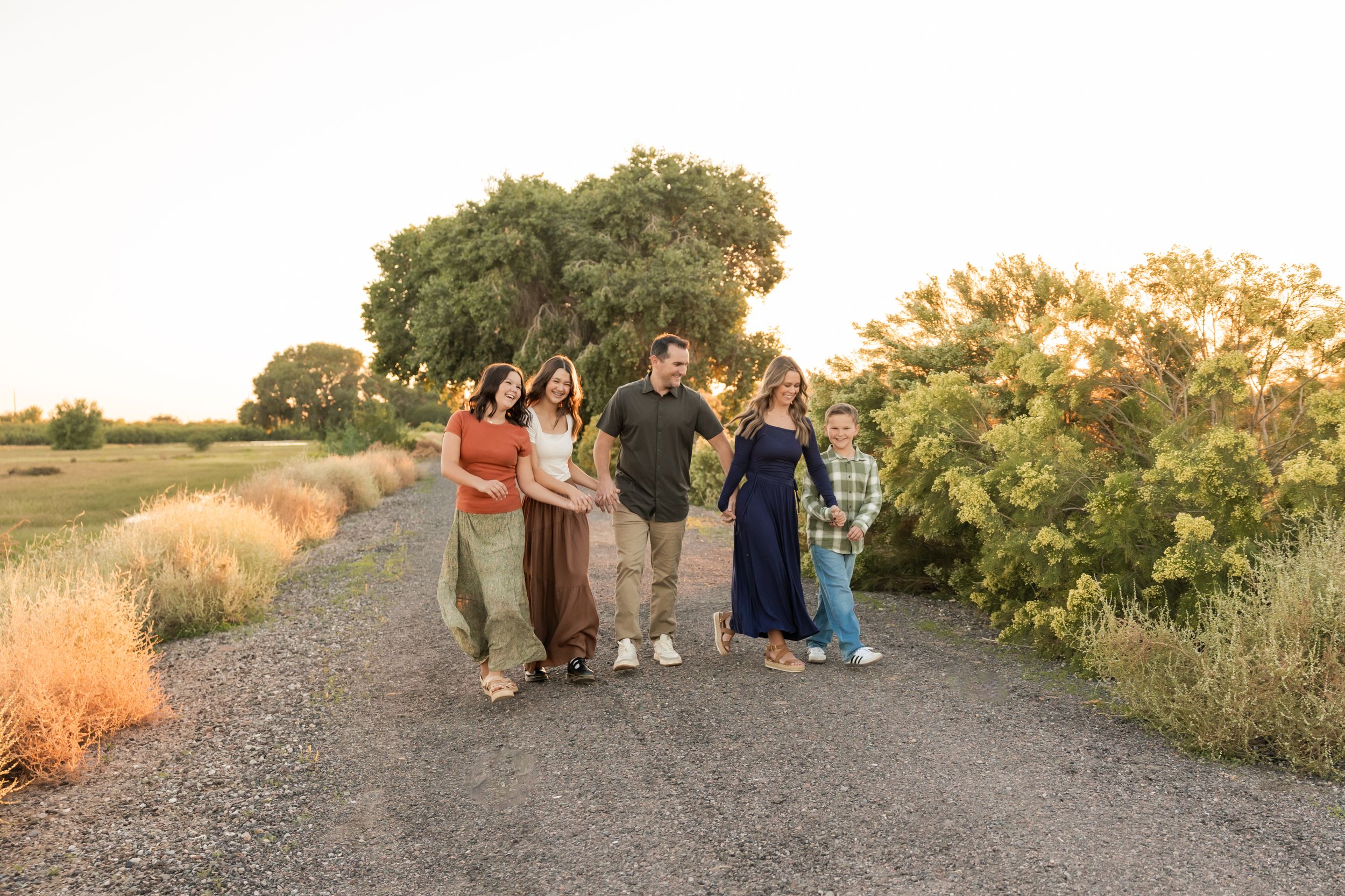 A panoramic sequence of people gathered outdoors at sunset watching an event along a desert trail.