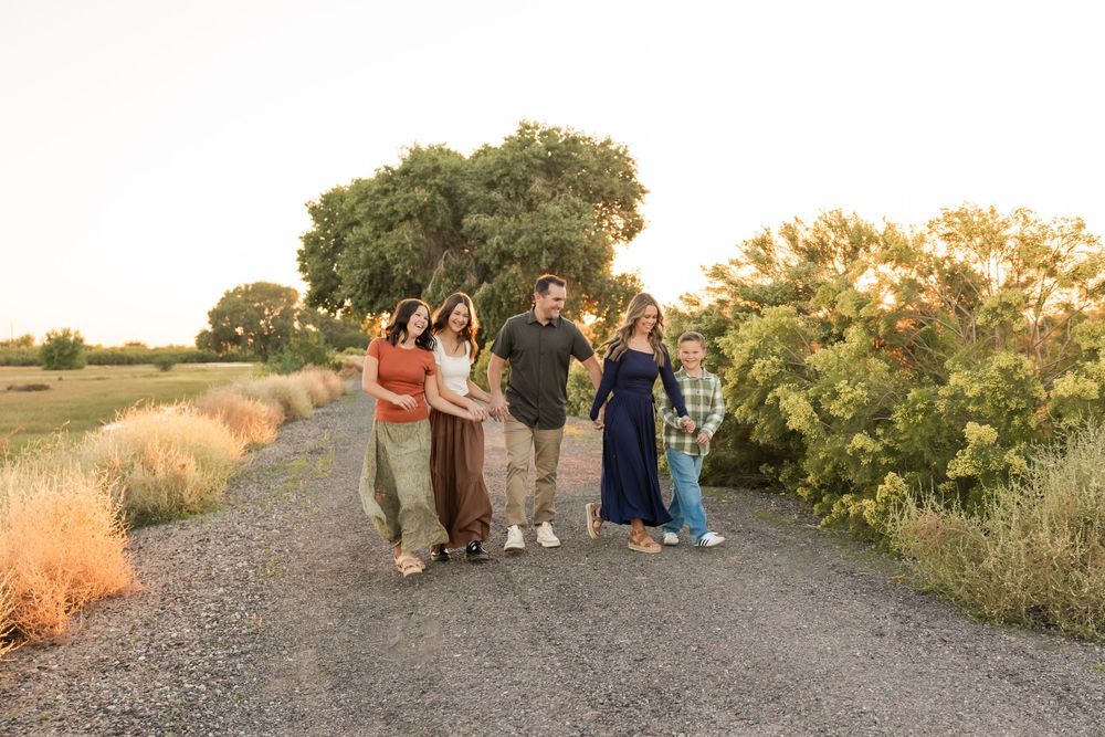 A panoramic sequence of people gathered outdoors at sunset watching an event along a desert trail.