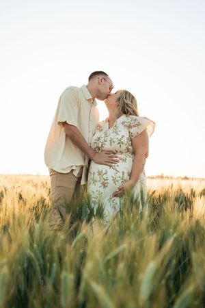 A romantic couple embraces in a golden wheat field during sunset in a multi-panel photo sequence.