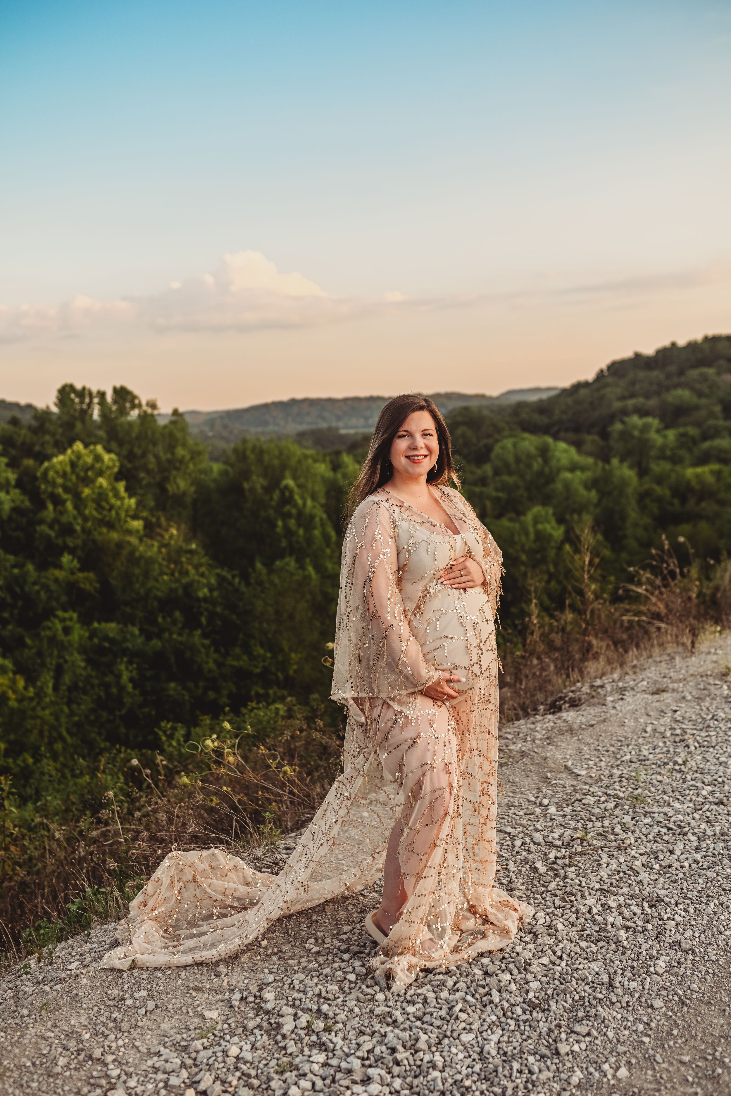Lace dress flowing in the breeze against a mountain landscape at sunset.