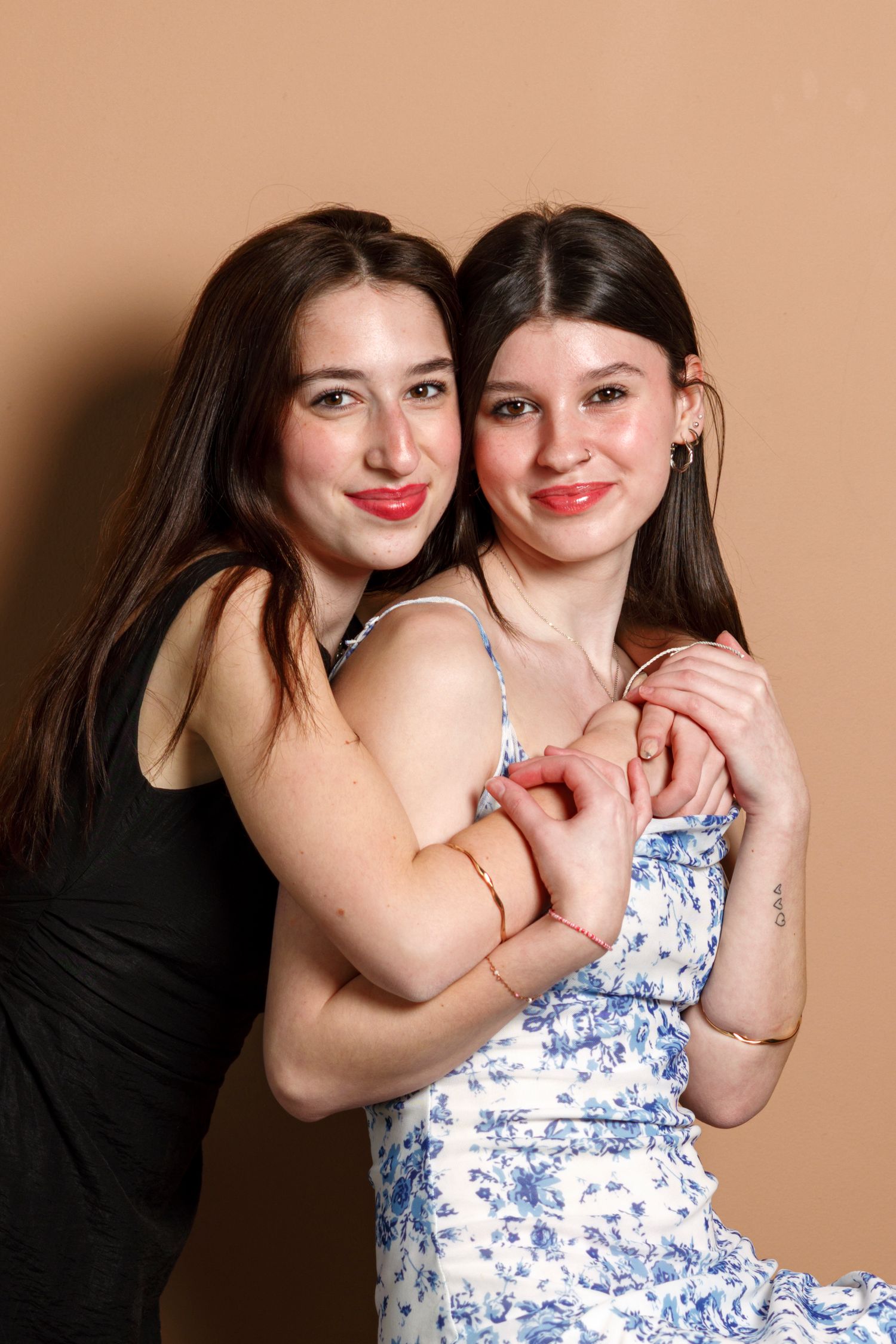 Two people in black and white floral dress pose together in a series of affectionate candid photos against beige background.