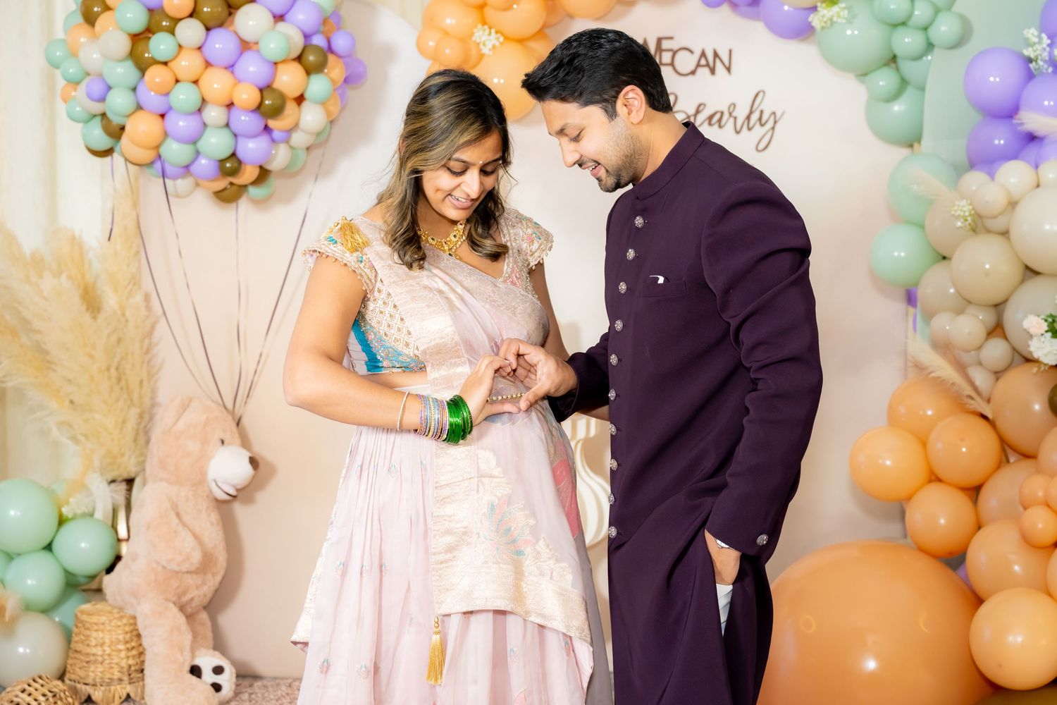 A romantic celebration with pastel balloon arches and decorations creating a dreamy atmosphere.